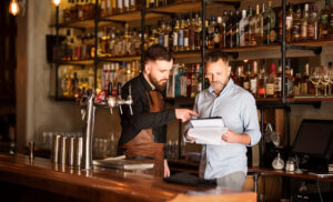 Shot of a bar manager and bartender checking the stock in the pub